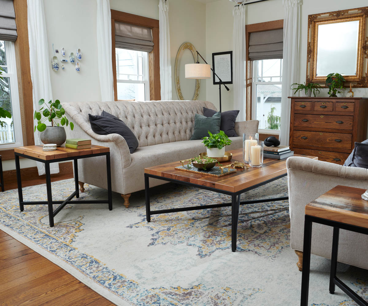 Cozy living room with quality sofas, hardwood furniture, and coffee table on patterned rug.